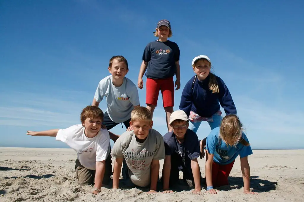 Kinder am Strand machen eine Pyramide