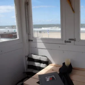 Innenraum von Badeturm. Links steht ein Stuhl und rechts ist ein Tisch auf dem ein Stammbuch liegt.