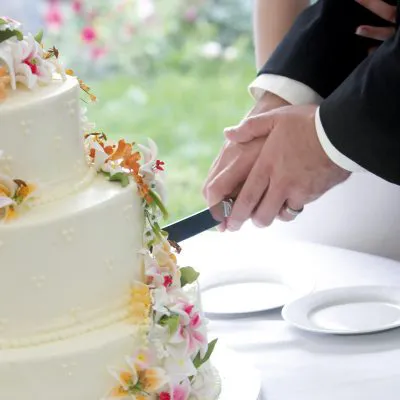 Das Brautpaar schneidet die Hochzeitstorte an.