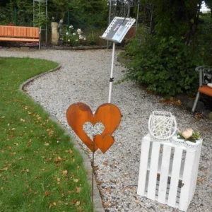 Metallherz steht im Rosengarten.